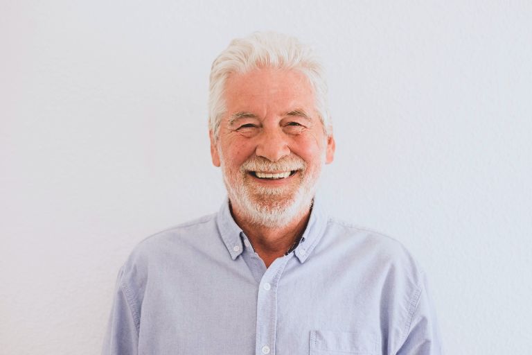 Hombre mayor sonriendo con Implantes dentales sin tornillos - Clínica Bousoño Vargas - Implantes dentales Oviedo