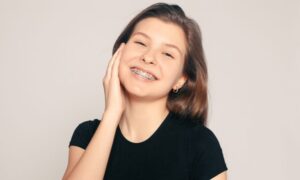 Chica sonriendo con brackets -Los aparatos de ortodoncia dañan tus dientes - Clínica Bousoño Vargas