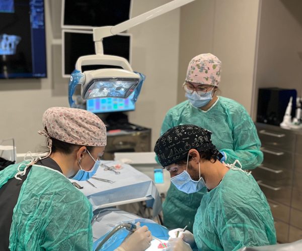 Dr. Carlos Bousoño y su equipo de implantología dental en el quirófano de la clínica Bousoño Vargas en Oviedo poniento implantes dentales a paciente